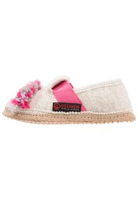 Chausson en feutre de couleur claire avec une sangle élastique rose, une décoration en laine texturée et une semelle en jute tissé. Présente une étiquette de marque sur le côté.