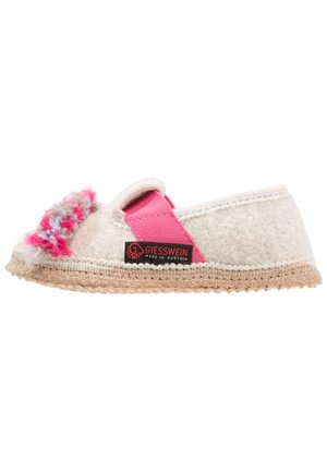Chausson en feutre de couleur claire avec une sangle élastique rose, une décoration en laine texturée et une semelle en jute tissé. Présente une étiquette de marque sur le côté.
