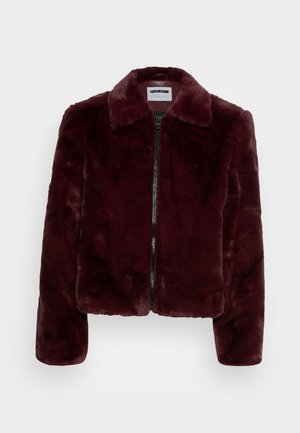 Veste en fausse fourrure bordeaux foncé avec manches longues, fermeture éclair devant et large col, présentée sur un fond clair uni.