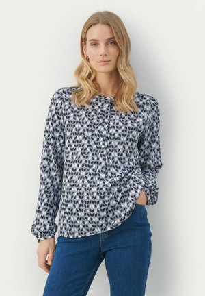 Camicia con bottoni caratterizzata da un motivo geometrico nei toni di blu, navy e bianco; maniche lunghe con polsini arricciati; orlo curvato; realizzata in tessuto leggero.
