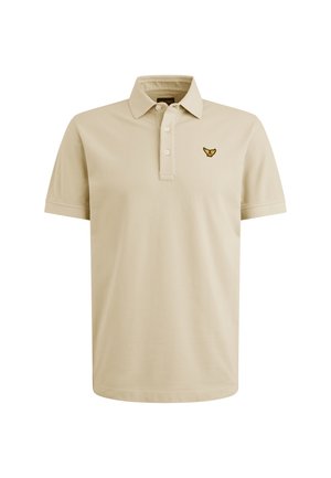 Bež majica polo izrađena od pamuka, s tri gumba na prednjem dijelu i izvezenim logotipom na lijevoj strani prsnog dela. Meka tekstura, kratki rukavi.