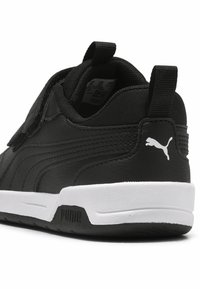 Svart sneaker med overdel i lær og syntetisk materiale, hvit gummisåle og teksturerte detaljer. Har logodetalj på hælen og drageløkke.