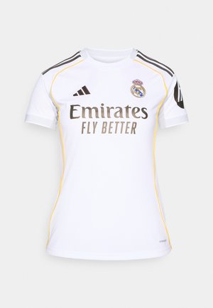 Biely jersey s krátkym rukávom, čiernymi detailmi, žltým lemom a logom "Emirates Fly Better". Obsahuje erb Real Madrid na hornej ľavej strane.