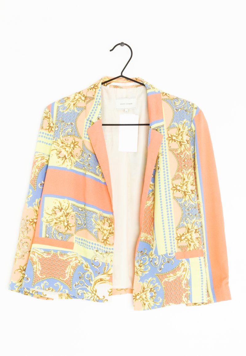 Blazer avec motifs floraux et géométriques colorés en orange, bleu, jaune et or, accroché à un cintre noir sur un fond blanc.