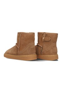 Bruine suède enkelboots met een textuurafwerking, voorzien van een zijrits, elastieken band aan de bovenkant en een rubberen zool.