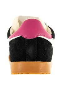 Schwarze Wildleder-Sneaker mit einer pinken Leder-Fersenlasche, weißer Zwischensohle und brauner Gummisohle. Texturierte Oberfläche mit abgerundeter Form.