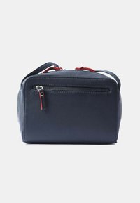 Borsa in pelle blu navy con forma rettangolare, dotata di manico superiore e dettagli rossi. Include una tasca con zip sul retro.