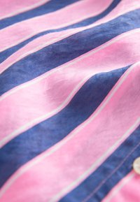 Striped fabric featuring pink and navy blue colors with white accent lines, displaying a soft texture and smooth finish.