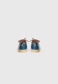 Pair of blue leather boat shoes with beige soles and brown laces, viewed from the back on a plain white background.
