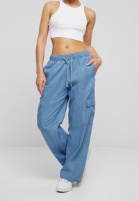 Světle modré nákladní kalhoty z denimu s elastickým pasem, šňůrkou a bočními kapsami, s volným a pohodlným střihem.