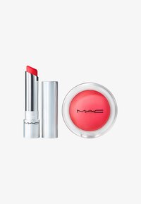 Rouge à lèvres MAC dans un tube argenté brillant avec un embout rouge vif, accompagné d'une boîte de fard à joues ronde avec une teinte rose douce et un couvercle transparent.