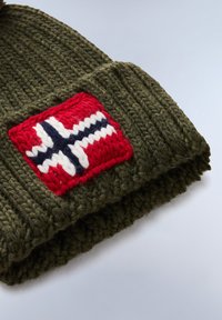 Berretto lavorato a maglia verde oliva con risvolto, caratterizzato da una toppa rossa con un emblema a motivo croce bianca e blu. Finitura in filato testurizzato.