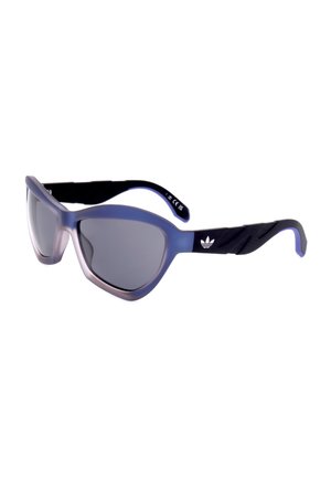 Occhiali da sole sportivi cat-eye con montatura traslucida blu, lenti scure e aste nere testurizzate con il logo Adidas bianco.
