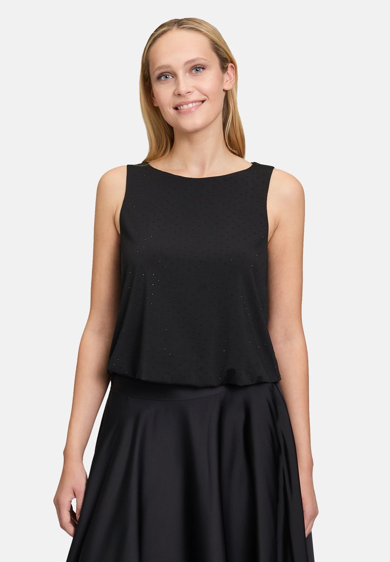 Schwarzes ärmelloses Oberteil mit runder Ausschnittform und lockerer Passform, das ein dezentes gepunktetes Muster und einen weichen, strukturierten Stoff aufweist.
