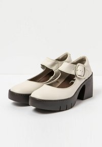 White leather Mary Jane shoes with a round toe, cut-out side, adjustable strap, and a chunky brown heel with vertical grooves.