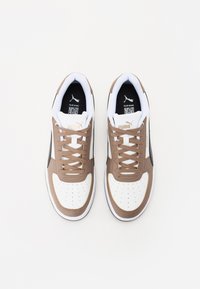 Weiße und braune Sneaker mit perforierter Zehenpartie, flachen Schnürsenkeln, gepolstertem Kragen und schwarzen Akzenten. Mit goldfarbenem Logo und schwarzem Innensohle.