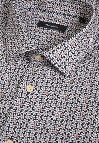 Camicia button-up con sfondo blu navy e motivo floreale in rosa, bianco e blu. Tessuto morbido e design del colletto classico.