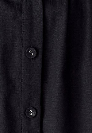 Tessuto nero con una fila di tre chiusure a bottoni, texture liscia e una leggera lucentezza sui bottoni per i dettagli.