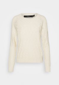 Krämfärgad tröja med en strukturerad stickad design, rund halsringning och långa ärmar. Ribbad mudd och fåll. Märket syns på insidan av kragen.