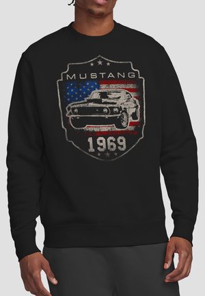 Black sweatshirt with vintage 1969 Mustang car graphic overlaid on a distressed American flag shield emblem.