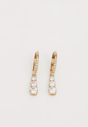 Złote kolczyki typu koła z trzema okrągłymi przezroczystymi kryształami i akcentem w kształcie diamentu wzdłuż zapięcia, charakteryzujące się gładkim, wypolerowanym wykończeniem.