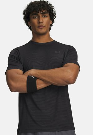 Black athletic t-shirt with a ribbed texture and short sleeves. Features a subtle logo and a fitted design. Accompanied by a black wristband.