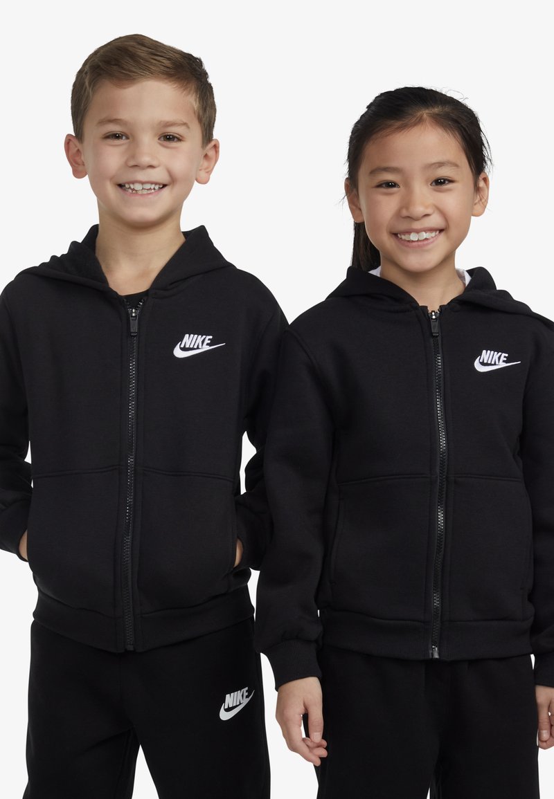 Fekete, cipzáras kapucnis pulóverek elülső zsebekkel, fehér Nike logóval a mellkason. Egy pár gyermek visel azonos ruházatot.