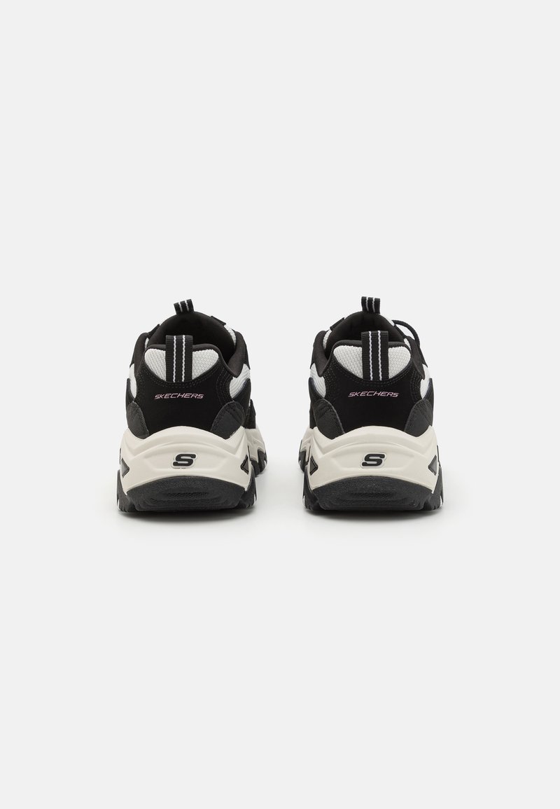 Schwarz-weiße Sneakers mit strukturiertem Obermaterial, gepolstertem Schaft, verstärktem Fersenbereich und kontrastierender Zwischensohle. Mit Branding auf der Rückseite.