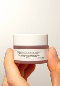 Super Jelly per il contorno occhi in un barattolo di vetro smerigliato, tinta lavanda, coperchio bianco e un'etichetta con testo nero. Contiene 15 mL di prodotto.