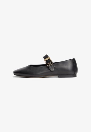 Chaussure plate Mary Jane en cuir noir avec un bout pointu et une bride à boucle dorée sur le dessus.