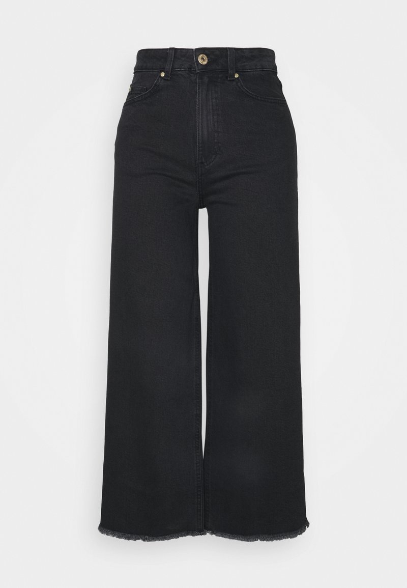 Vaqueros negros de talle alto con pierna ancha y dobladillo deshilachado, con detalles en botón y costuras en tono dorado. Diseño clásico de cinco bolsillos.