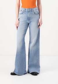 Lyseblå vide jeans med høy midje, fem-lommer design og subtil fading. Materialet ser ut til å være solid denim med en jevn tekstur.