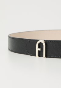 Black leather belt with a textured finish, featuring a gold-tone metal buckle shaped like the letter "A." Simple and sleek design.
