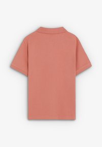 Camiseta polo rosa polvo lisa de manga corta con cuello doblado, vista desde atrás sobre un fondo blanco.