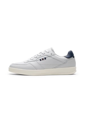 Hvid lavtop sneakers med cremet sål, snørebånd foran, navy hæl-flap og lille stribet logo-detalje på siden.