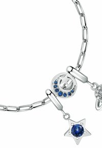 Bracciale in argento a catena con charm a forma di luna e stella, decorato con gemme blu e trasparenti, che mette in risalto dettagli intricati e texture lisce.