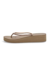 Chancla de color marrón claro con una suela de plataforma texturizada y tiras delgadas trenzadas para un ajuste seguro. Diseño plano con un aspecto casual.