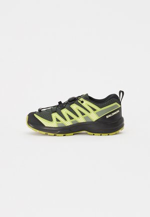 Salomon túracipő fekete és neon zöld hálós anyagból, texturált felülettel. Biztonságos fűzőrendszerrel és strapabíró gumitalppal rendelkezik.