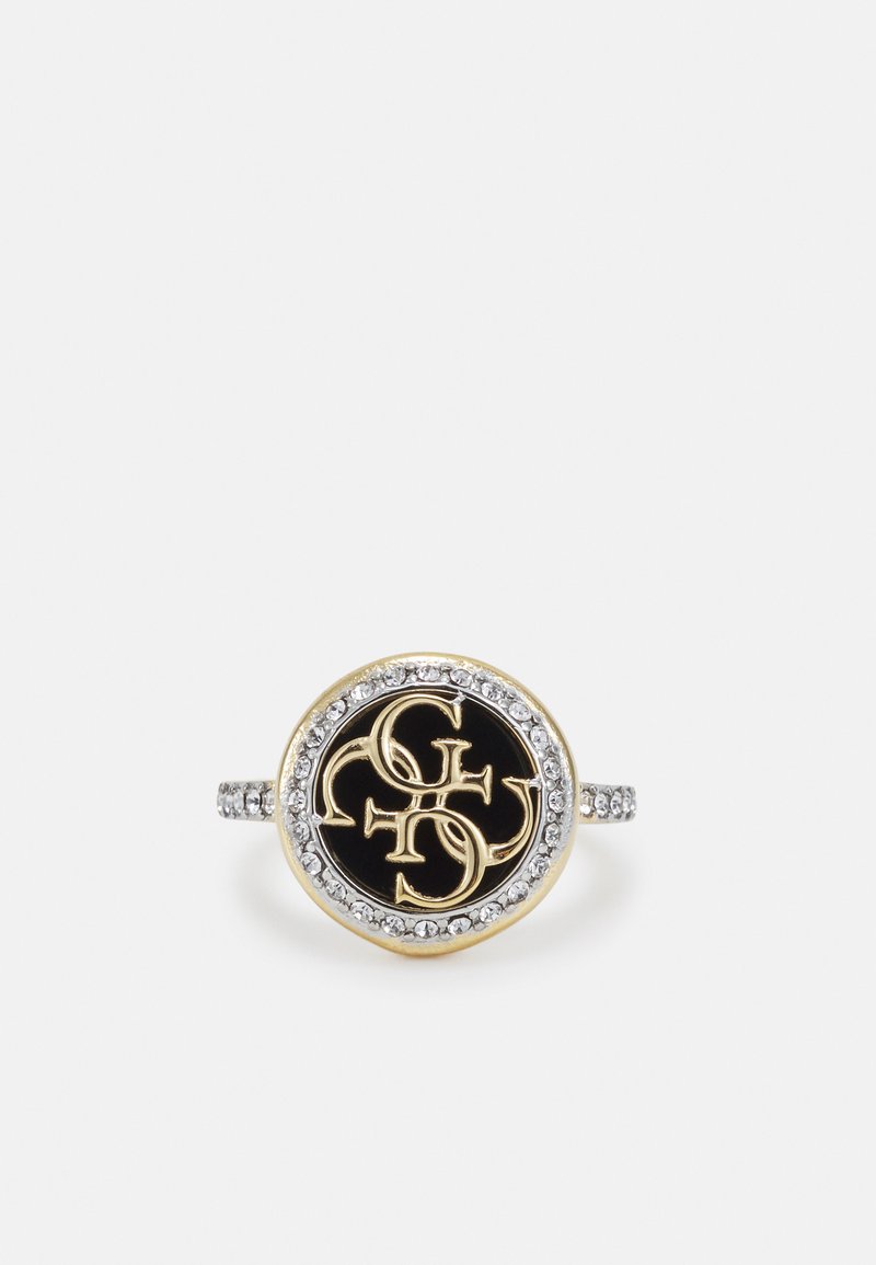 Anello in oro e argento con un volto rotondo in smalto nero caratterizzato da iniziali intrecciate e un bordo circolare di pietre trasparenti.