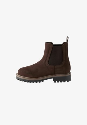 Bota Chelsea de ante marrón con paneles elásticos en los lados, tirador y una suela de goma texturizada. Presenta costuras en contraste y una punta redondeada.