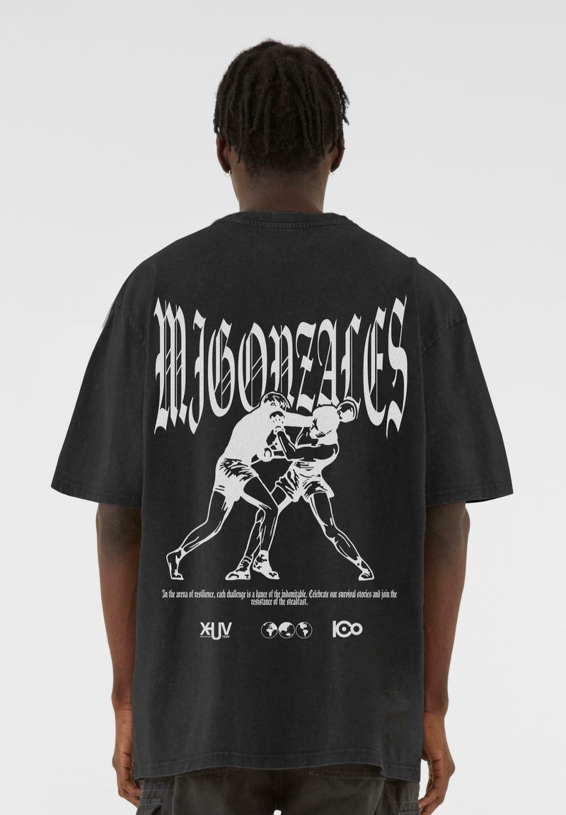 Sort oversized t-shirt med et hvidt grafisk tryk af to boksere og tekst. Korte ærmer og rund halsudskæring.