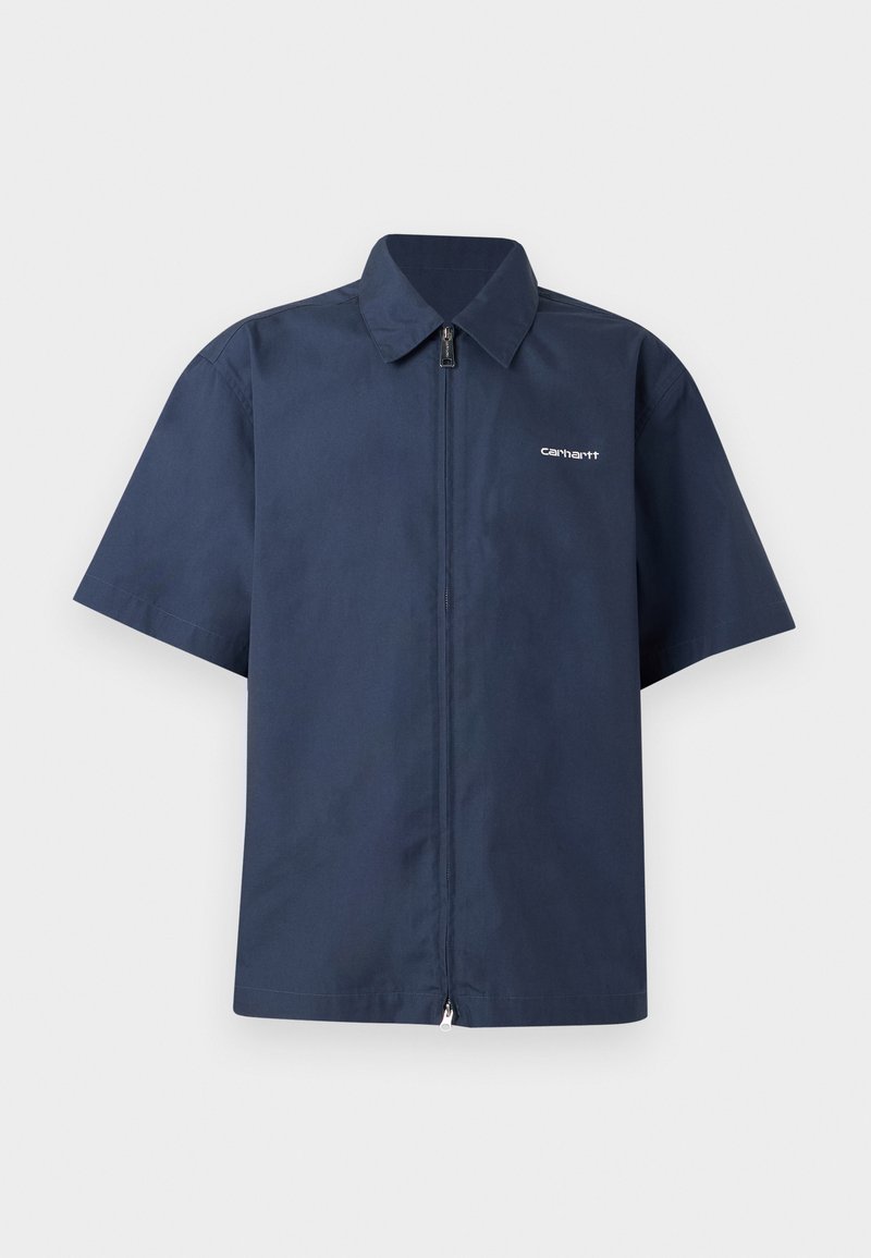 Chemise zippée à manches courtes bleu marine avec col, petit logo blanc « Carhartt » sur la poitrine gauche, présentée sur un fond uni.