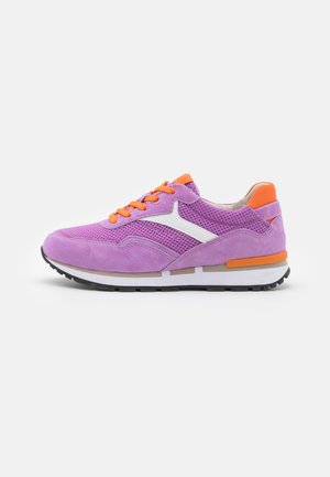 Paarse en oranje sportieve sneaker met mesh en suède bovenzijde, witte zijkant detail, oranje veters en zwarte loopzool die naar links wijst op een witte achtergrond.