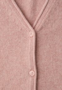 Cardigan rose clair en tricot avec un col en V, doté d'une fermeture par un seul bouton et d'une texture douce. Le tissu présente un motif fin et régulier.