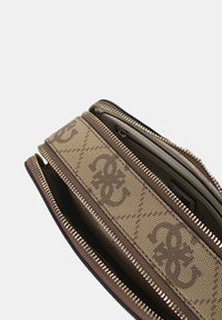 Portafoglio in canvas monogram marrone con Zip in tonalità oro, multiple sezioni, finitura testurizzata e dettaglio a strisce decorato. Design compatto.