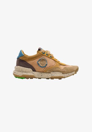 Zapatilla de deporte marrón claro de ante y cuero con suela crema moteada, lengüeta azul en el talón y parche con borde azul en el lateral.