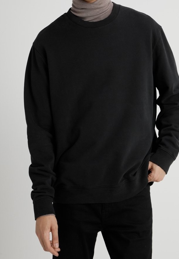 Sweat-shirt noir à col ras du cou, coupe décontractée, en tissu doux et lisse ; poignets et ourlet côtelés avec un design simple et classique.