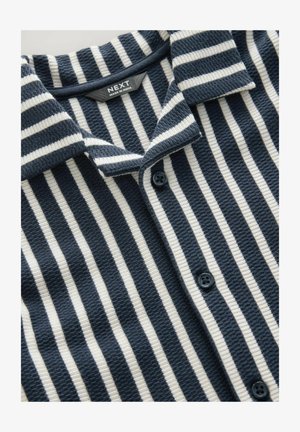 Marineblå og cremefarvet stribet strikketrøje med krave, knaplukning, tekstureret stof og kontrastknapper.