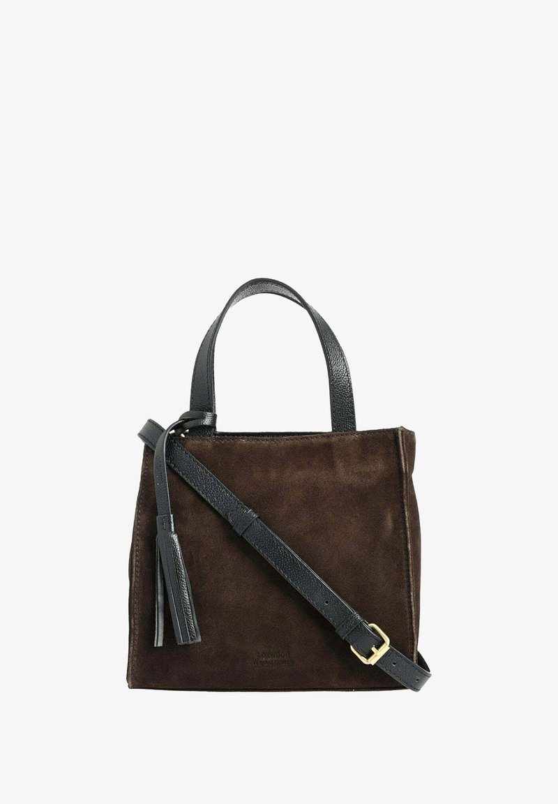 Sac à main en suède marron avec de courtes poignées en cuir noir et une bandoulière amovible. Présente un pompon et un design minimaliste.