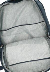 Dunkelblaues Innenfutter eines Rucksacks mit einem hellgrauen Stofffutter, ausgestattet mit einem großen Fach, zwei Reißverschlusstaschen und einem weich strukturierten Trennteil.